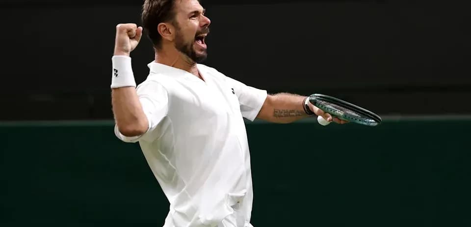 Tennis player celebrating victory with racket raised