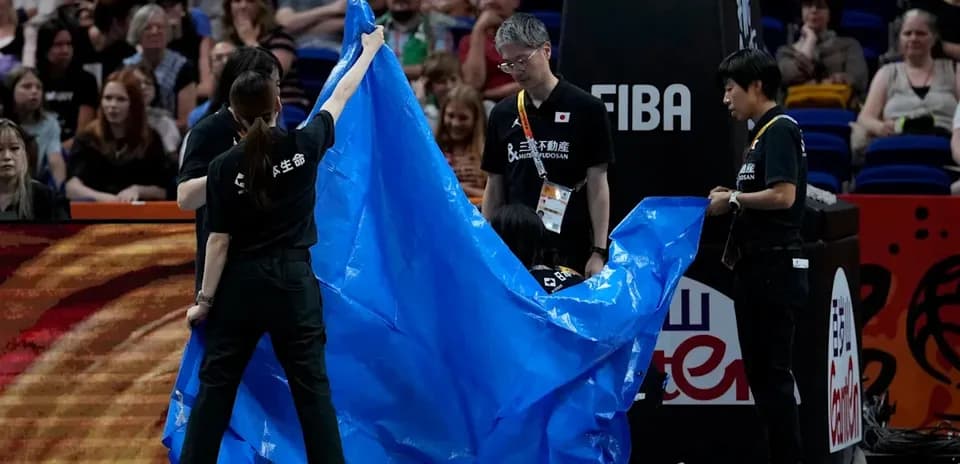 Staff covering the court with a blue tarp