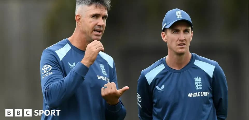 Coaches discussing strategy during cricket training session