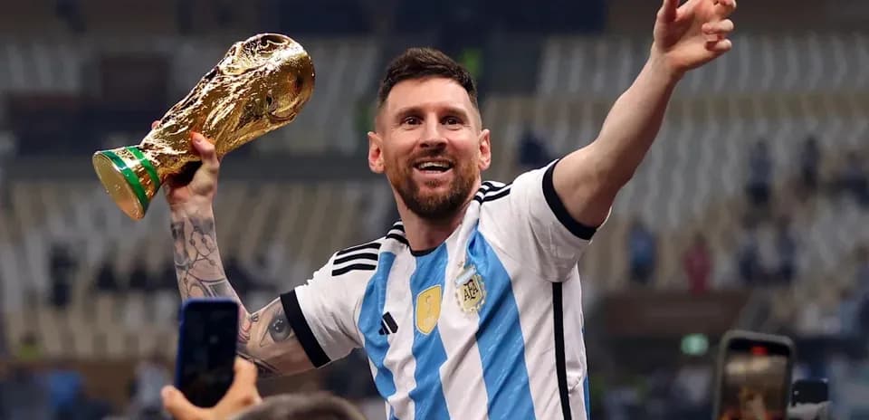 Player celebrating with World Cup trophy in stadium