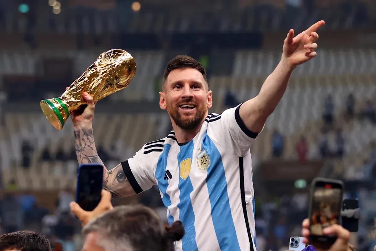 Player celebrating with World Cup trophy in stadium