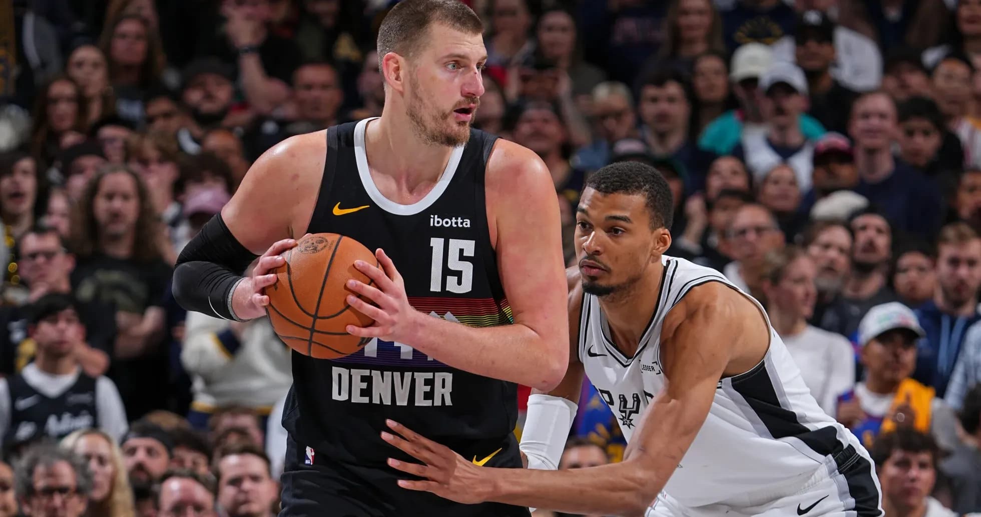 Nikola Jokić dribbling while being closely guarded