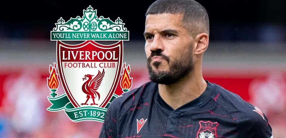 Player in black jersey with Liverpool logo in background