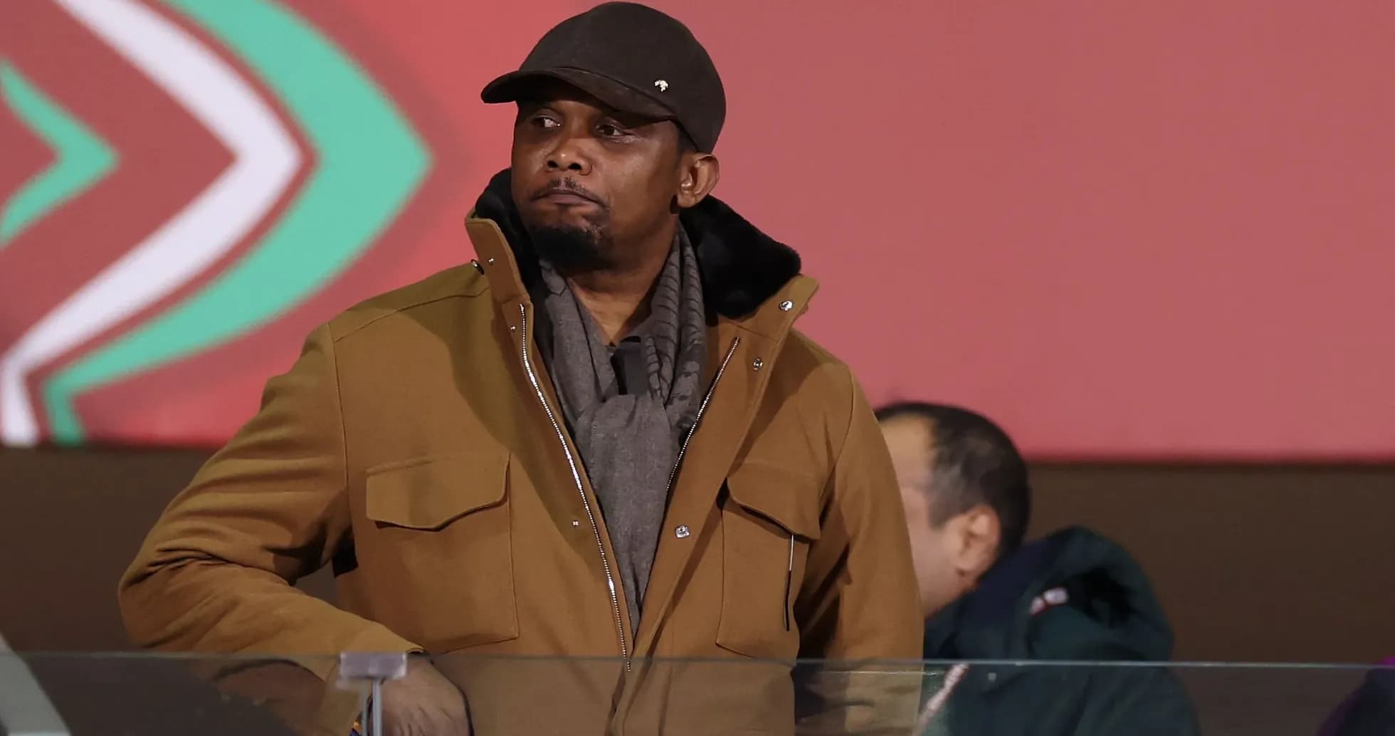 Man in brown coat and hat at event