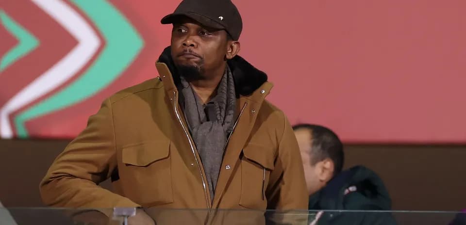 Man in brown coat and hat at event