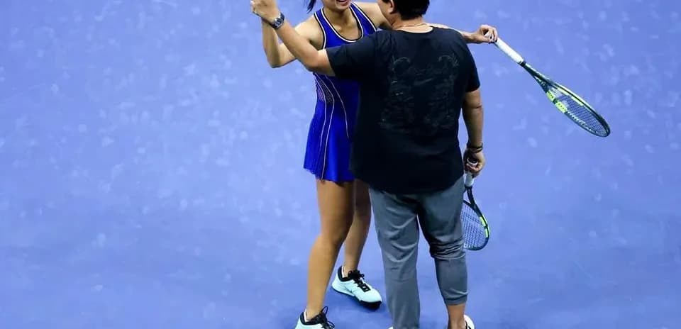 Player celebrating with coach after match victory