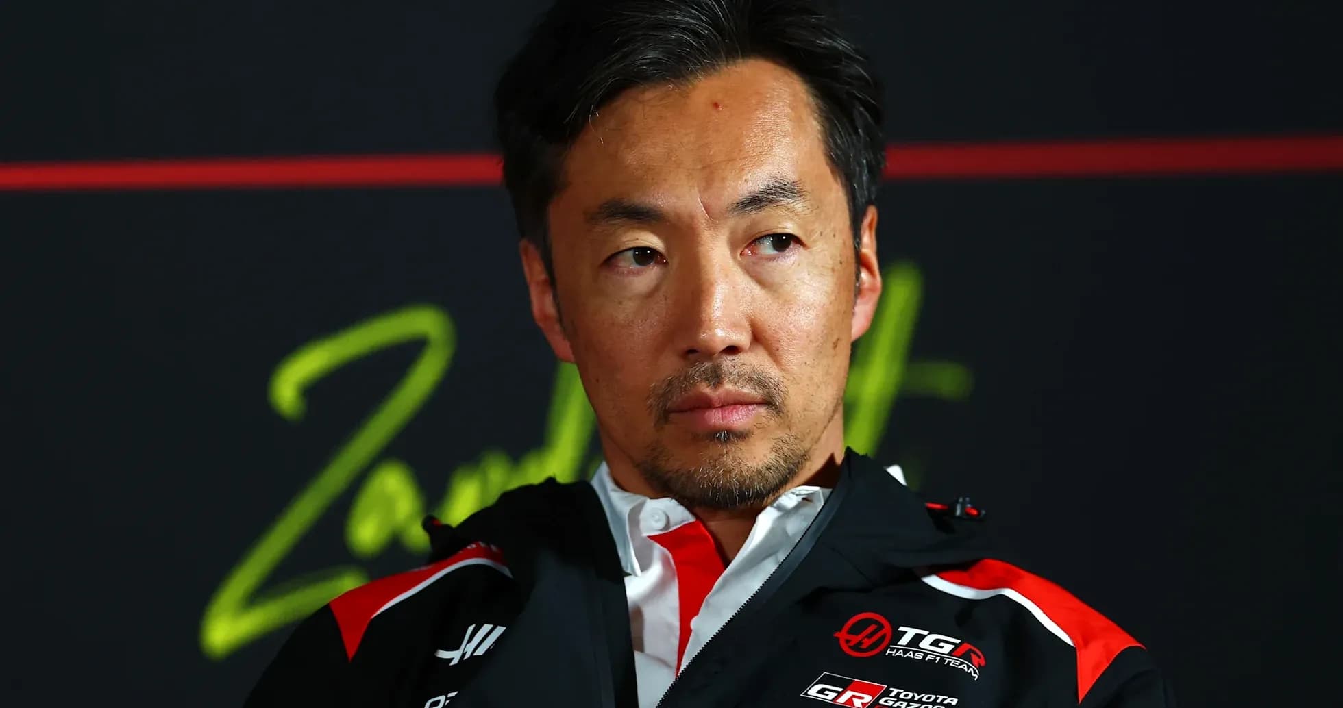 Team principal at press conference with serious expression