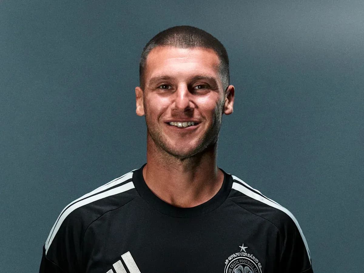 Player posing in black jersey with club logo