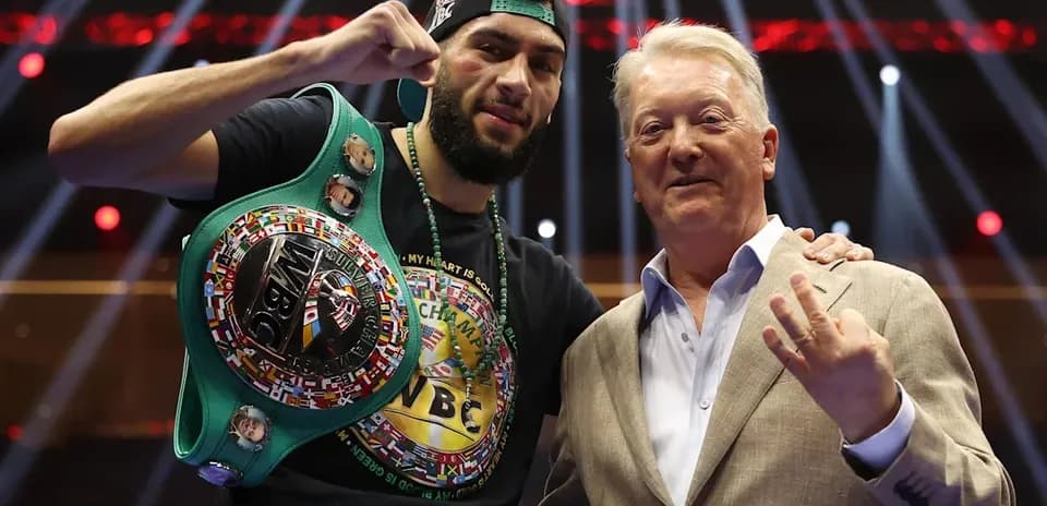 Boxer holding WBC title with promoter in ring