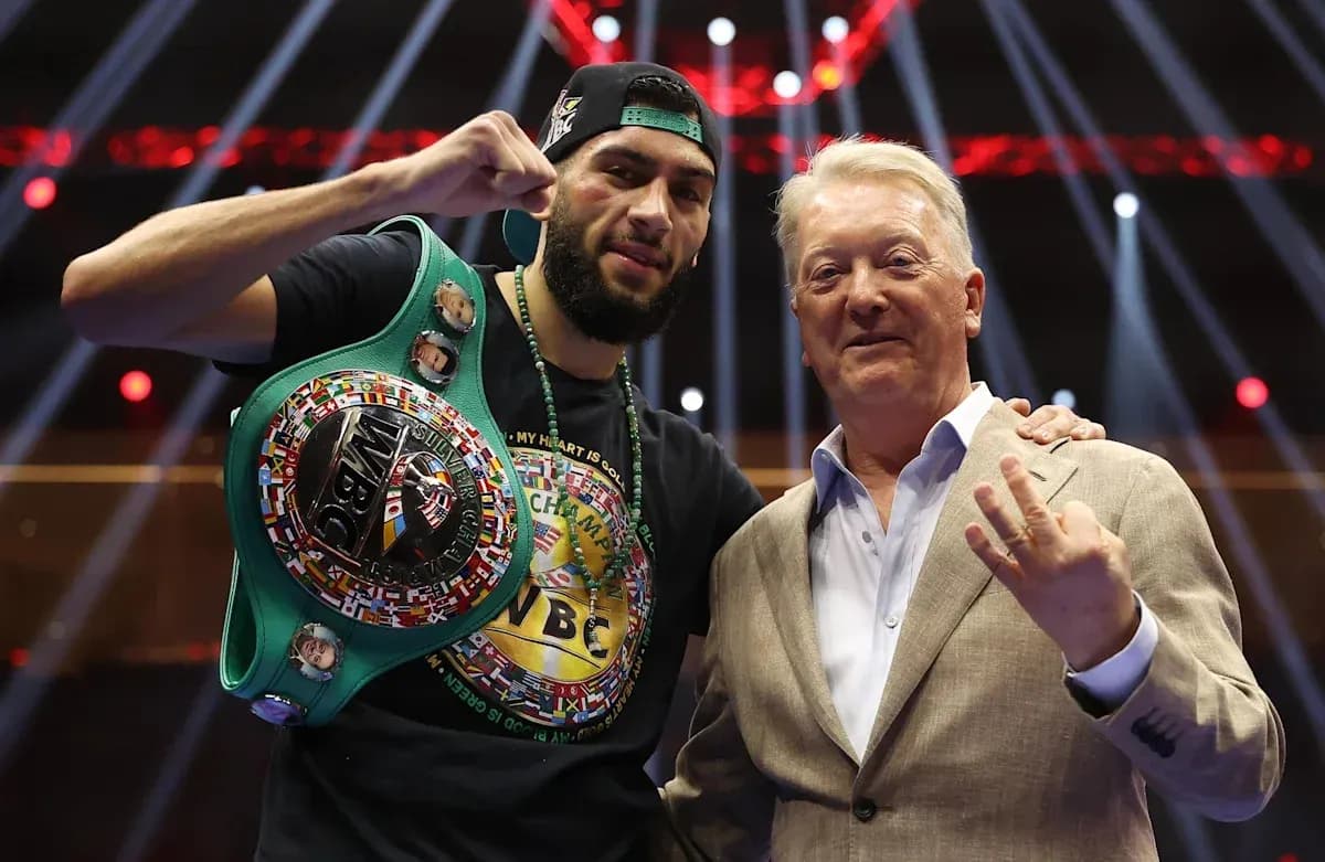 Boxer holding WBC title with promoter in ring
