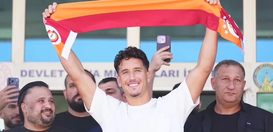 Player holding Galatasaray scarf at announcement event