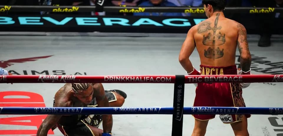 Boxer on canvas while opponent stands nearby