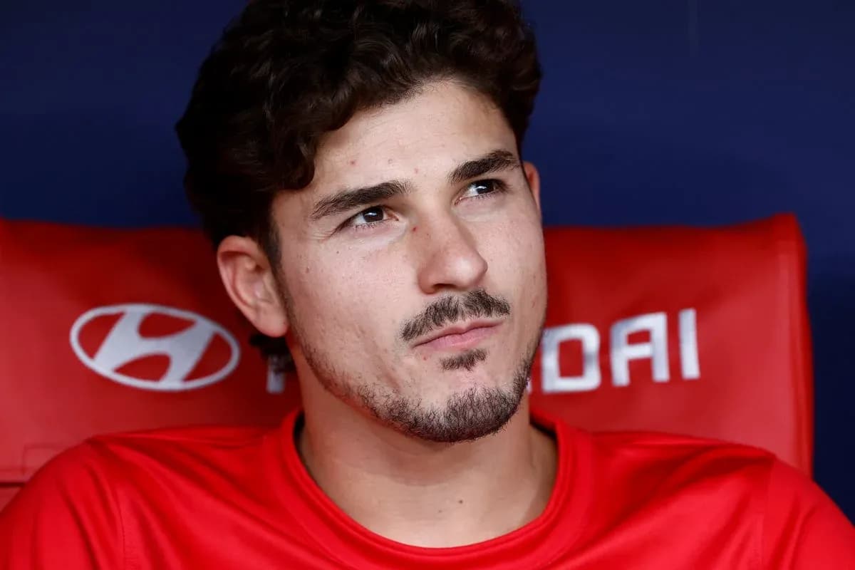 Player sitting on bench in red team jersey