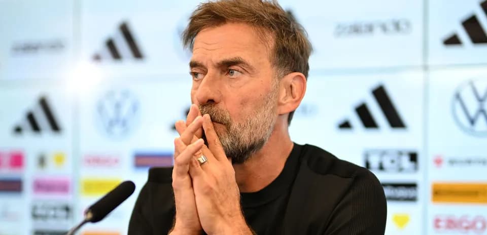 Manager at press conference with logos in background