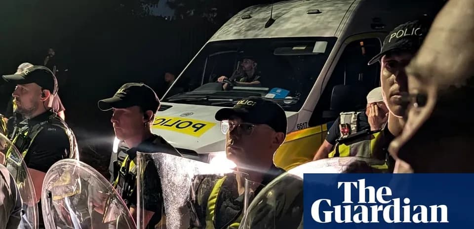 Police officers with shields near police van