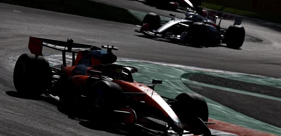 Formula 1 cars racing on a track corner