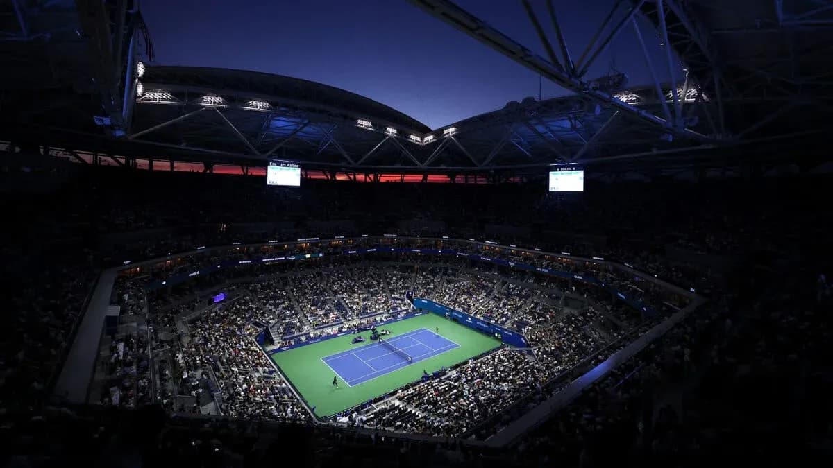 Crowd watching tennis match under stadium lights