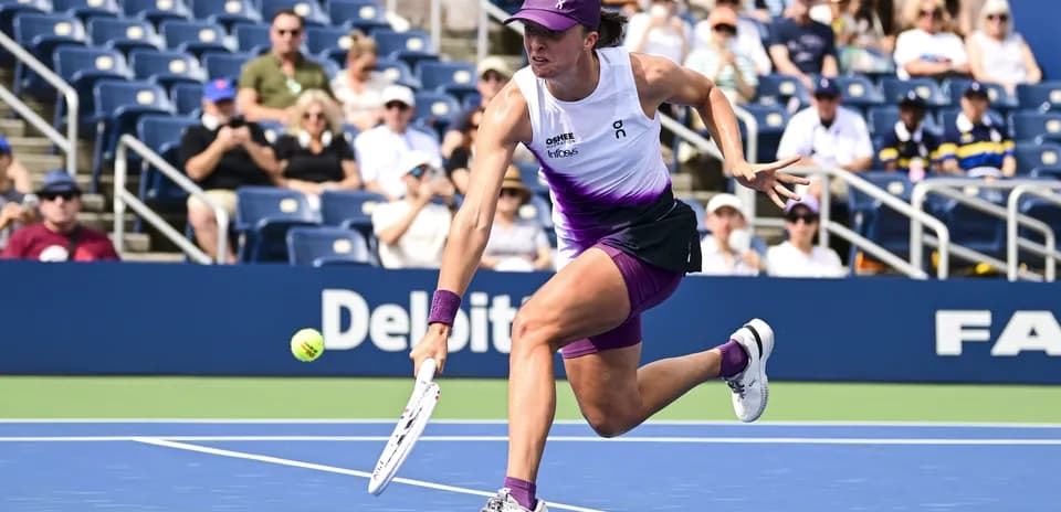Player reaching for a tennis ball on court