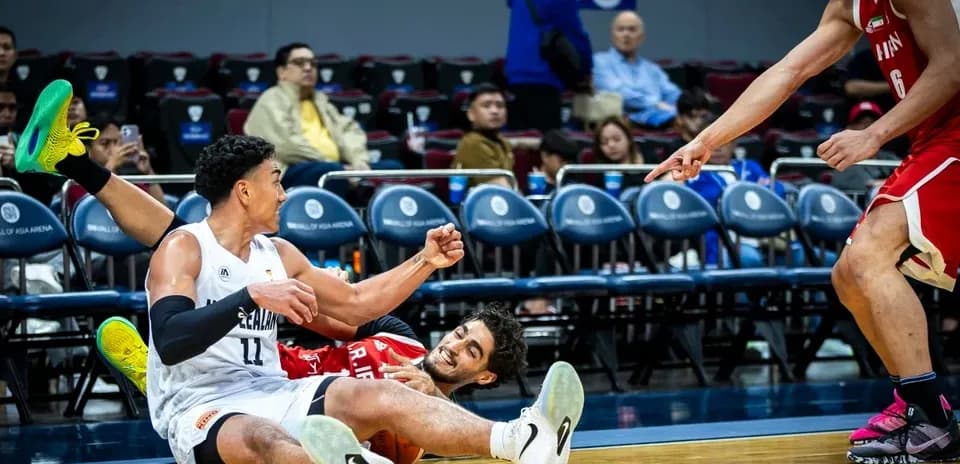 Two basketball players on the floor during game