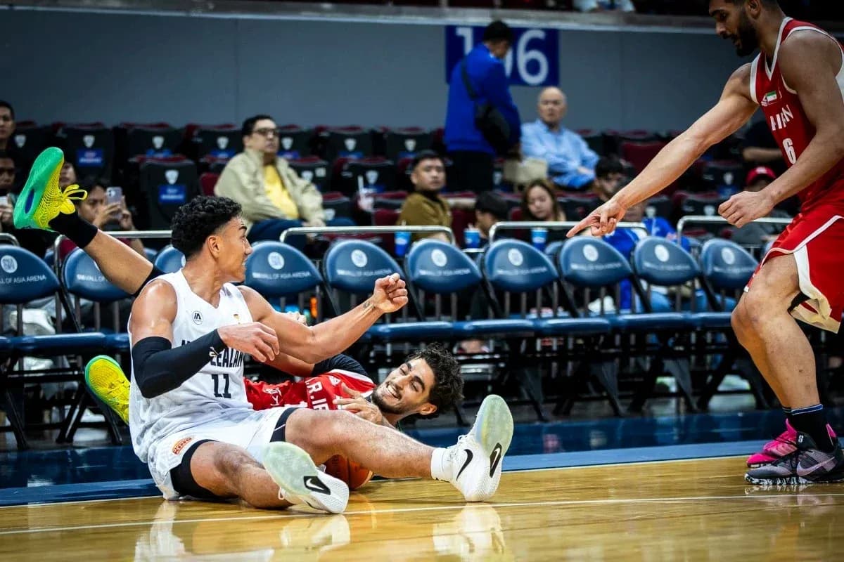 Two basketball players on the floor during game