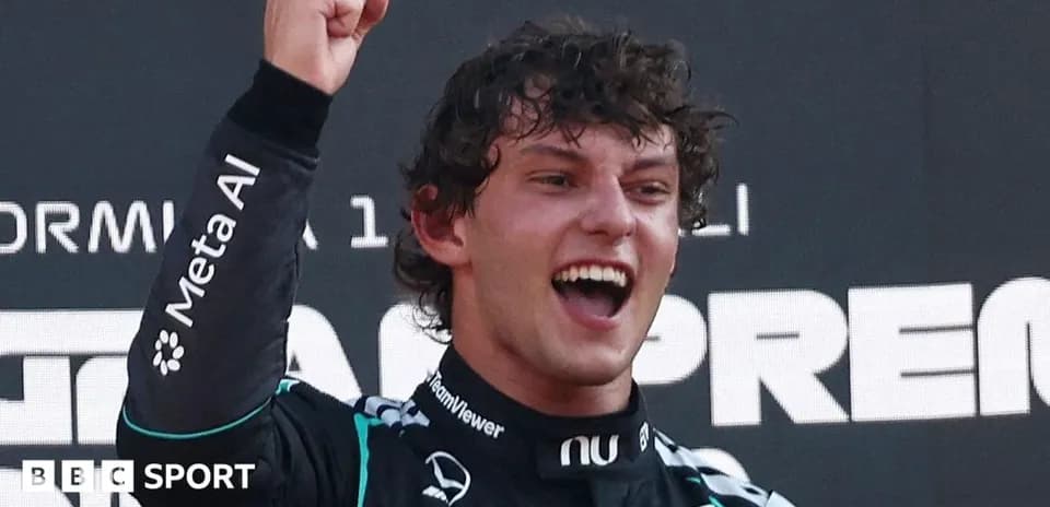 Driver celebrating victory with raised fist on podium