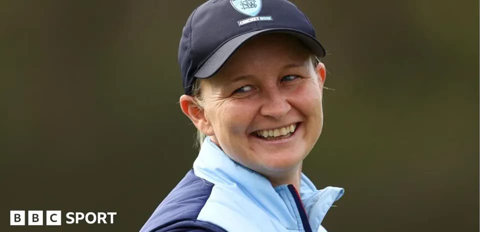 Woman smiling in cricket cap and jacket