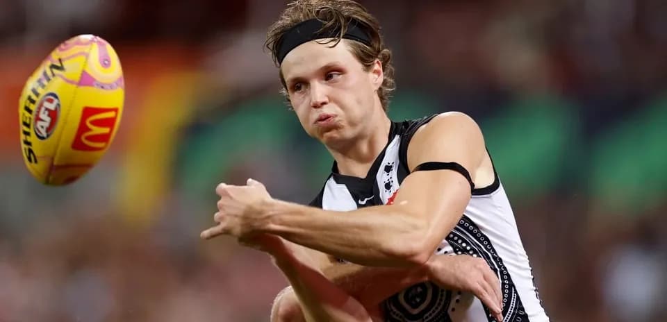Player kicking an Australian football during match
