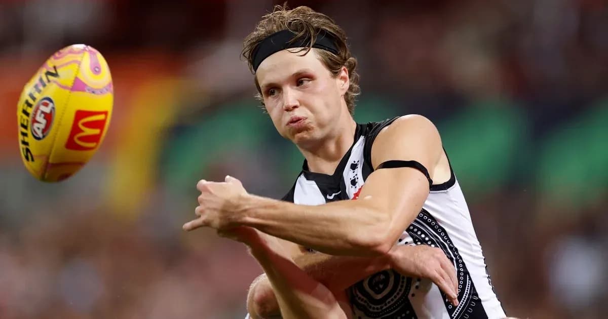 Player kicking an Australian football during match