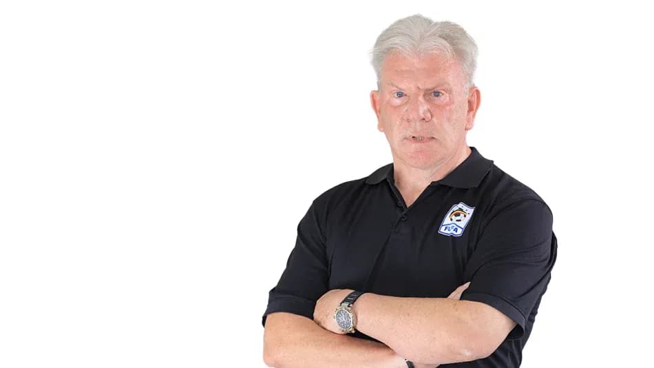 Coach with arms crossed, wearing black polo shirt