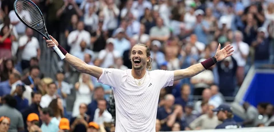 Tennis player celebrating with arms raised in crowd