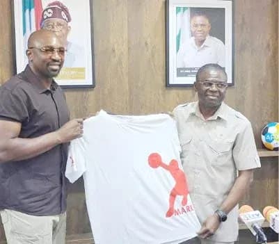 Two men holding a T-shirt in an office