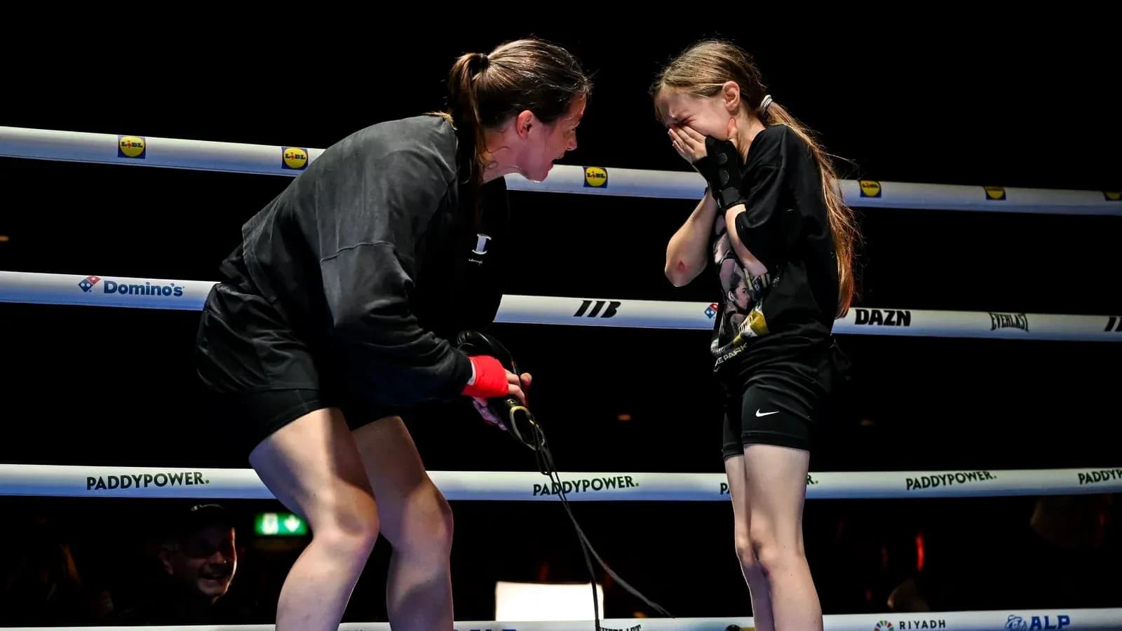 Boxer comforting young girl in the ring