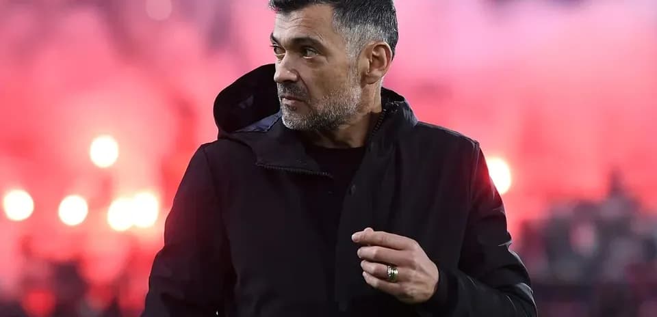 Coach observing the match with smoke in background