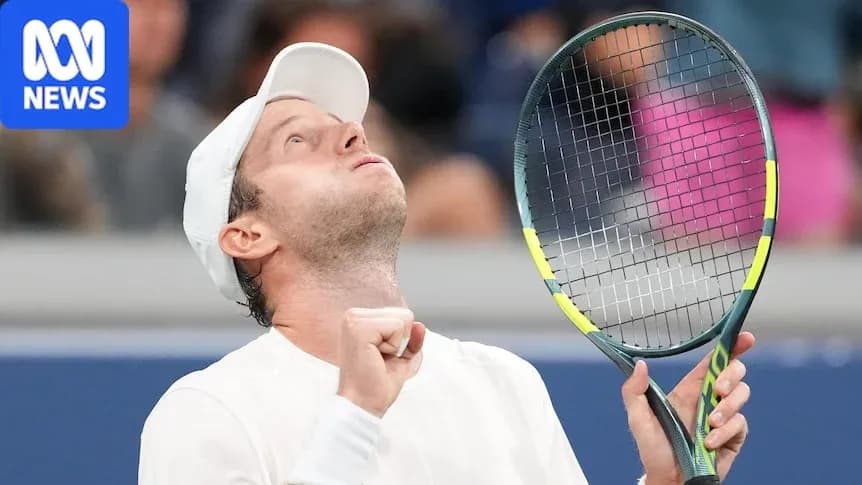 Tennis player celebrating victory with racket raised