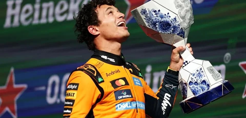 Driver celebrating with trophy on podium after race