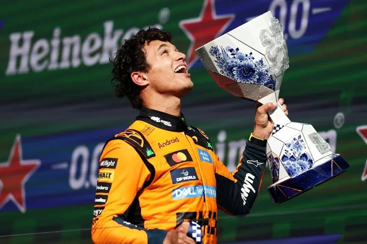 Driver celebrating with trophy on podium after race