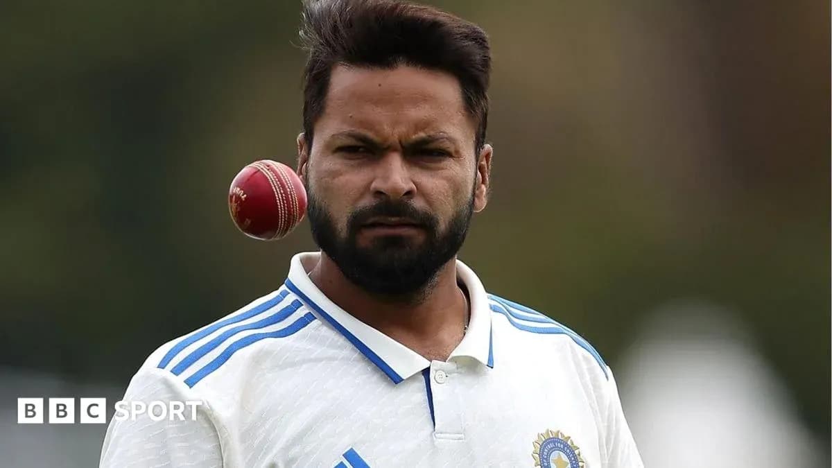 Cricketer preparing to bowl with a red ball