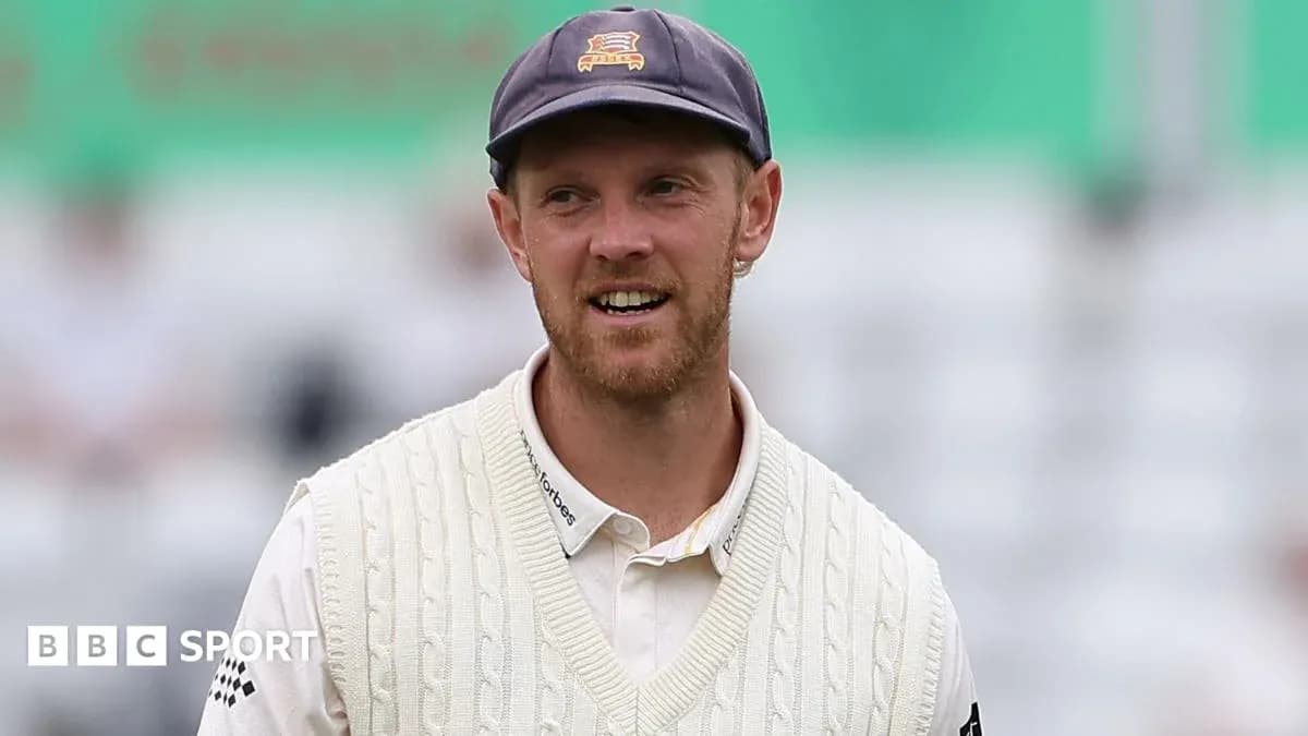 Cricketer wearing a sweater and cap on field