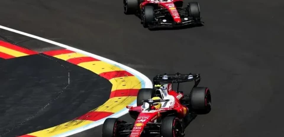 Two Ferrari cars navigating a racetrack corner