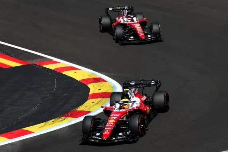 Two Ferrari cars navigating a racetrack corner