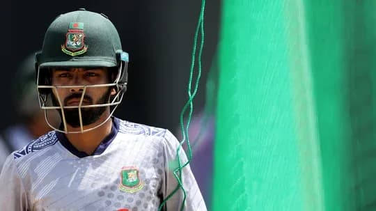 Cricketer in helmet walking towards practice nets