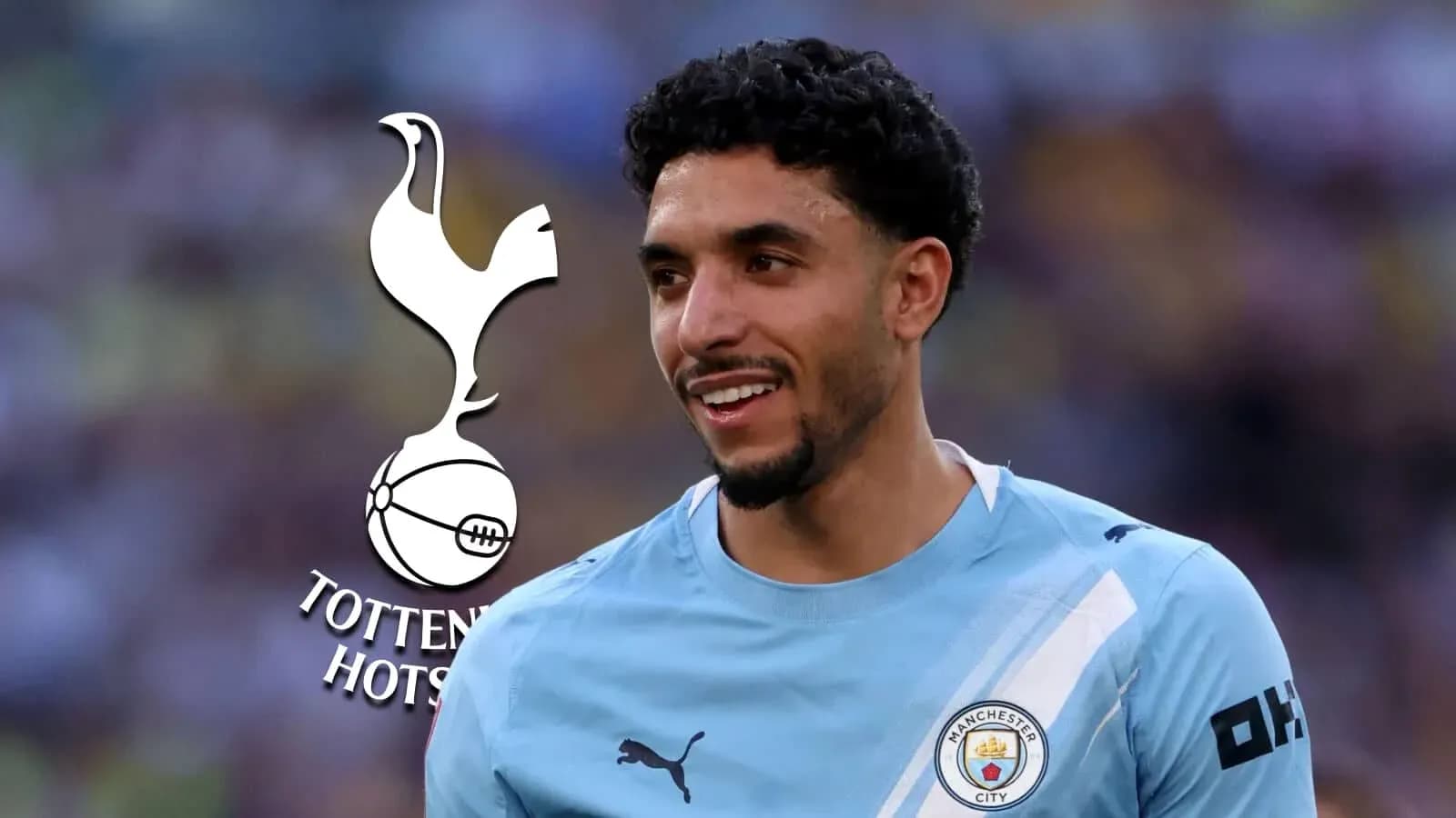 Player smiling in Manchester City kit with logo