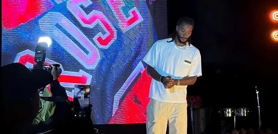 Artist performing on stage with bright backdrop