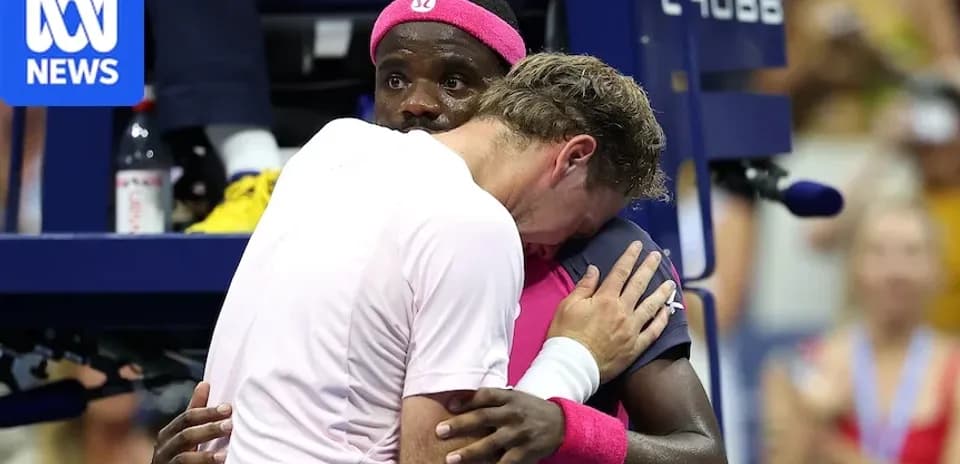 Two tennis players embracing at the net