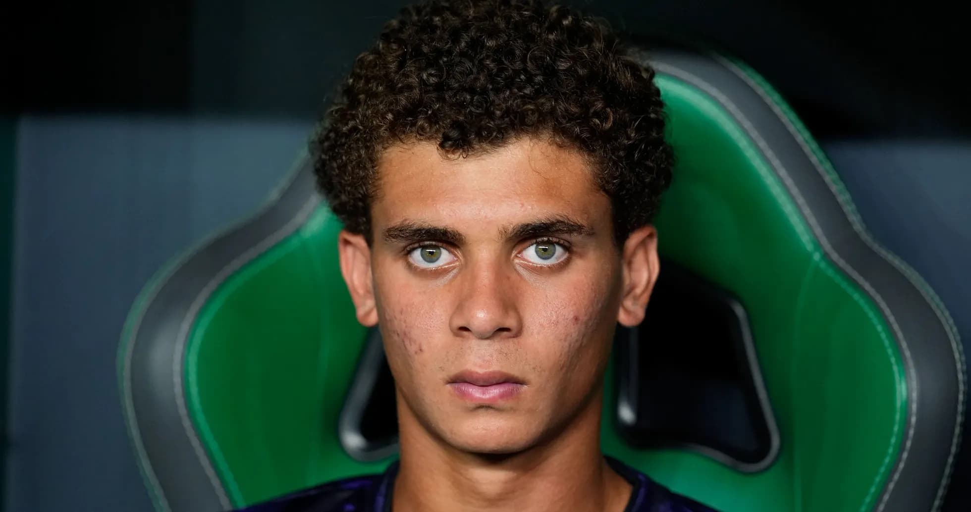 Young player sitting in sports chair, focused expression