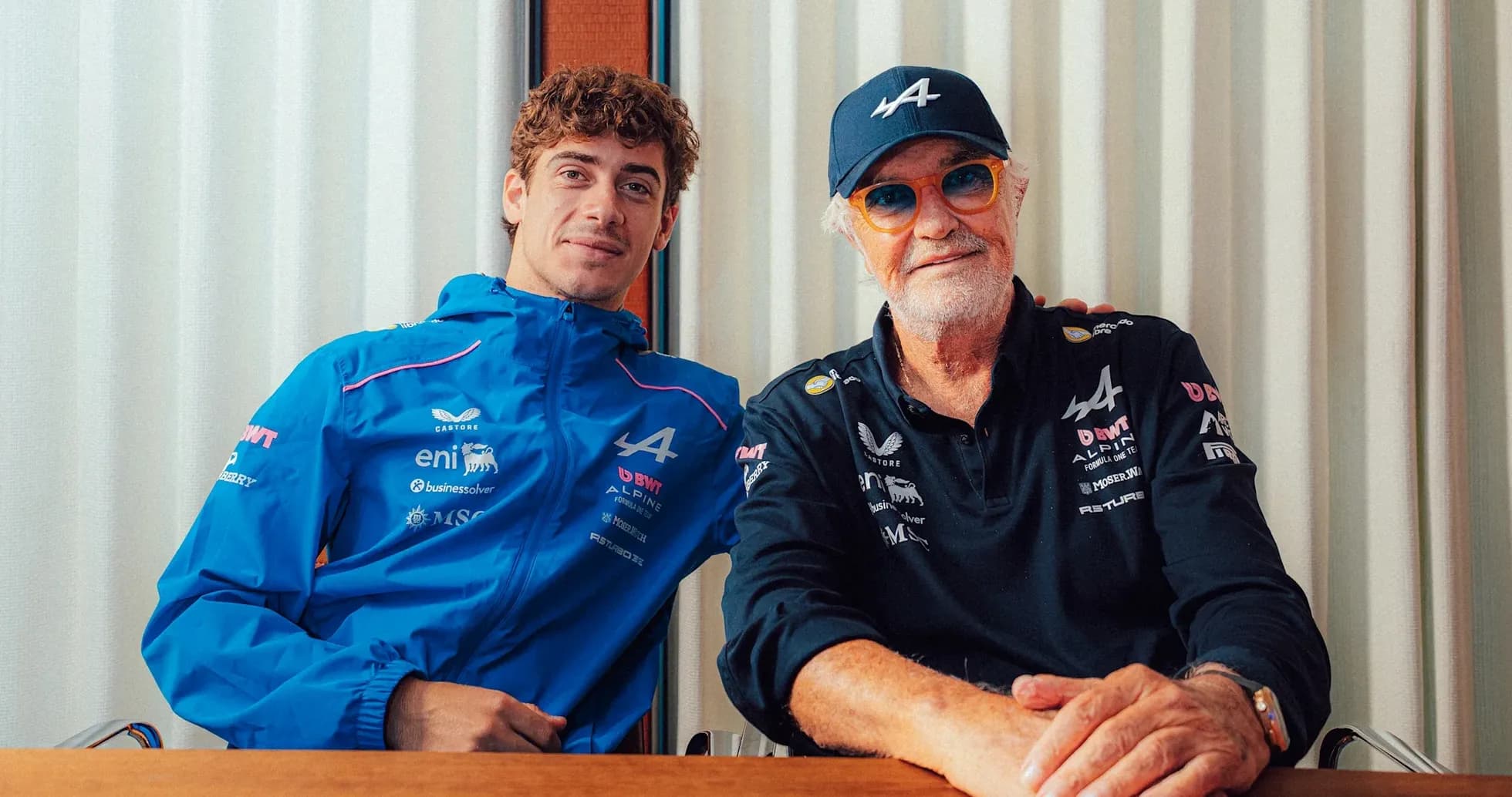 Two men posing together in Alpine team attire