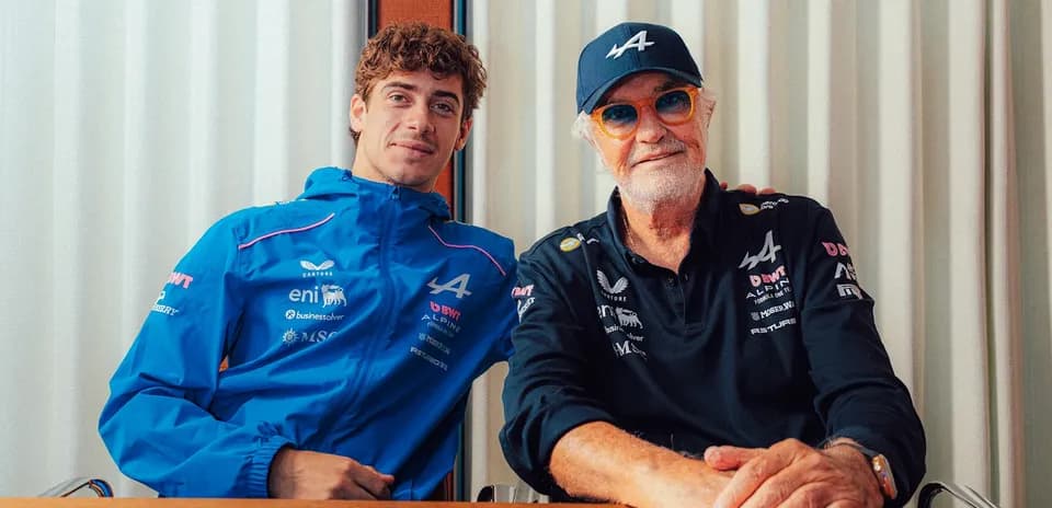 Two men posing together in Alpine team attire