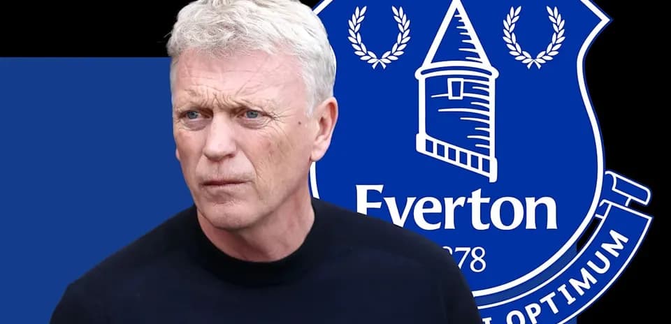Manager in front of Everton logo background