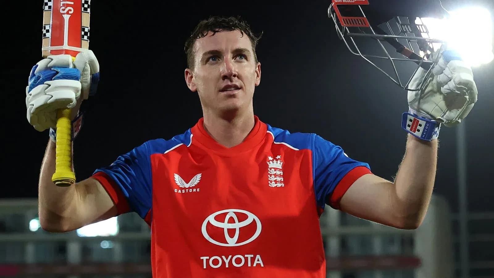 Batsman celebrating with bat raised after scoring