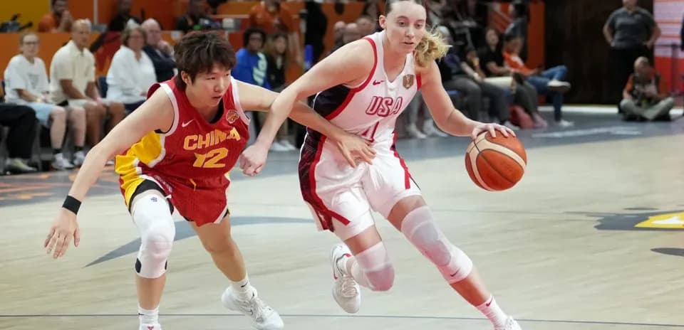 USA player dribbling past China player during game